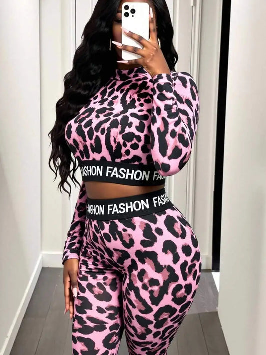 Person wearing a pink leopard print outfit with 'Fashion' text, taking a mirror selfie.