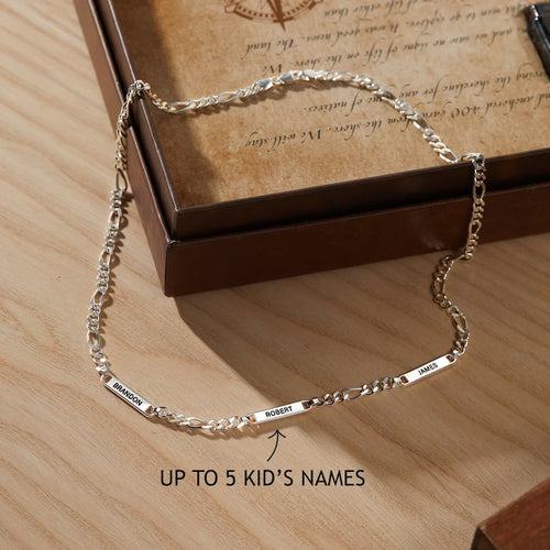 Silver bracelet with engraved names on a wooden surface